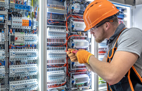 Elettricista al lavoro su un quadro elettrico secondo le procedure di sicurezza previste dalla norma CEI 11-27 per personale PES, PAV e PEI.