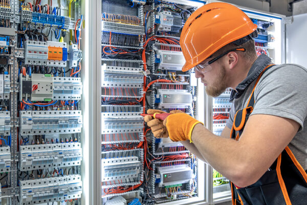 Elettricista al lavoro su un quadro elettrico secondo le procedure di sicurezza previste dalla norma CEI 11-27 per personale PES, PAV e PEI.